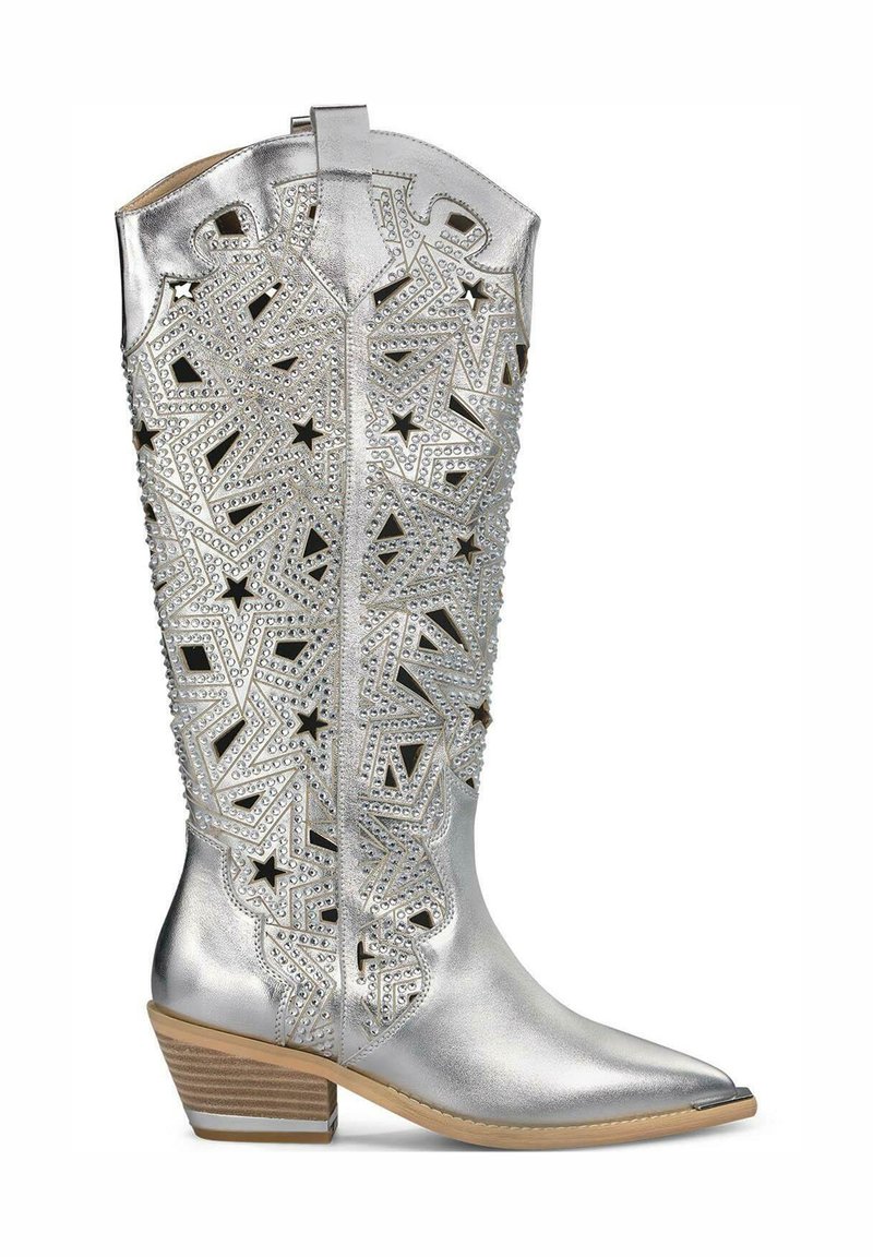 Stivale da cowboy argento con fori a forma di stella decorativi, impreziosito da borchie, punta appuntita e tacco a blocco. Texture metallica liscia.