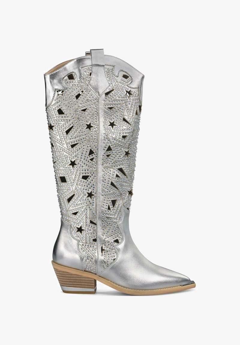 Botte de cowboy argentée avec des découpes d'étoiles décoratives, embellie de clous, orteil pointu et talon empilé. Texture métallique lisse.