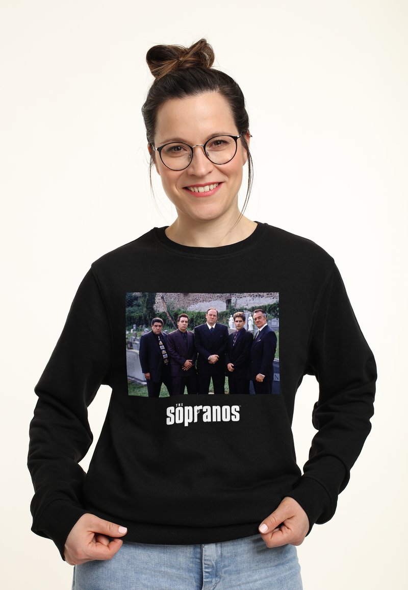 Felpa nera con una stampa grafica frontale di sei personaggi all'aperto, con il testo "The Sopranos" in un audace font bianco.