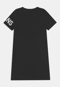 Černé šaty na tričko z bavlny, s kulatým výstřihem a krátkými rukávy. Na levém rukávu je bílým písmem vytištěn nápis "SNA".