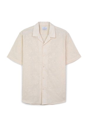 Camicia a maniche corte di colore crema con ricami floreali e dettagli a occhio; presenta un colletto classico e chiusura frontale con bottoni.