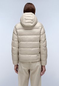 Beige puffjakke med horisontale quiltede sektioner, en tætsiddende hætte og ribbede manchetter, lavet af et glat, shiny stof.