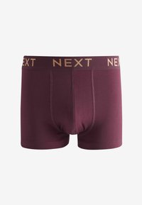 Boxer-briefs pour hommes bordeaux avec une ceinture logo "NEXT" dorée et des coutures détaillées, offrant un ajustement confortable et une texture de tissu douce.