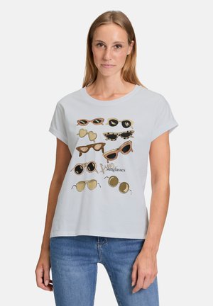 Light blue T-shirt featuring various illustrated sunglasses in black, gold, and animal print, with short sleeves and a relaxed fit.