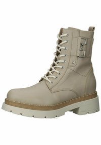 Botín de cuero beige hasta el tobillo con cordones blancos, suela más gruesa y detalles en hardware plateado. Punta redonda, superficie texturizada y acentos cosidos.