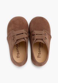 Pantofi din suede maro cu vârfuri rotunde, două găuri pentru șireturi și un suprafață texturată. Interiorul are o brant neted cu logo-ul mărcii.
