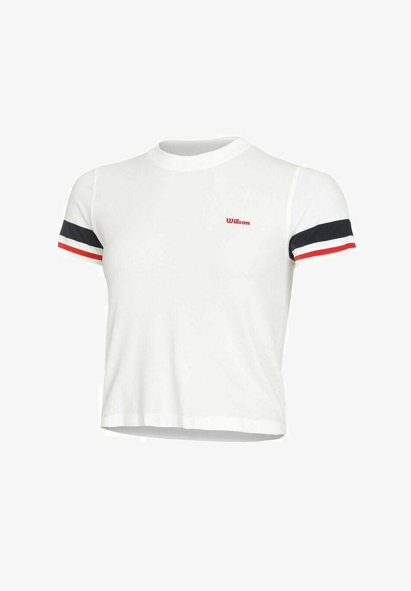 Camiseta blanca recortada de mangas cortas. Presenta acentos en rojo, azul marino y blanco en las mangas. Logo rojo de "Wilson" en la parte delantera.