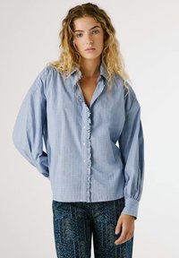 Helles blaues, langärmliges Hemd mit durchgehender Knopfleiste und Rüschenkragen. Eine leicht lockere Passform, hergestellt aus einem strukturierten Stoff.