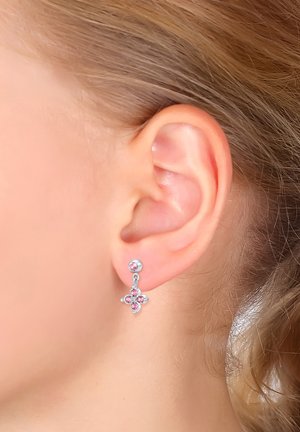 Orecchini a goccia in argento con design floreale, decorati con quattro gemme rosa e un piccolo chiodino sopra. Finitura in metallo liscia con accenti lucidi.