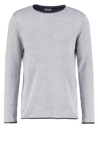 Světlý šedý svetr s dlouhým rukávem a kulatým výstřihem, s kontrastním tmavým lemem, pletenou texturou a uvolněným střihem.