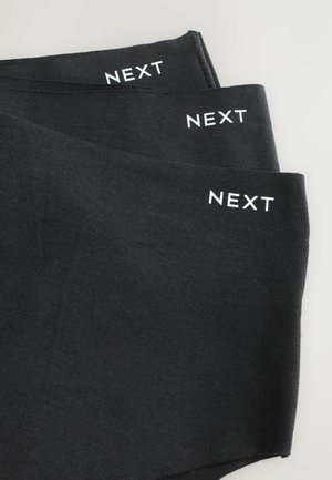 Mustat legginsit pehmeällä pinnalla, joissa on valkoinen "NEXT" -brändäys yläreunassa. Yksinkertainen muotoilu, ei näkyviä kuvioita tai koristeita.