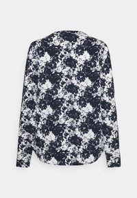 Blus med långa ärmar i marinblått och vitt blommönster, med avslappnad passform, klassisk krage och något böjd fåll. Mjuk tygtextur.