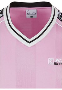 Pink sports jersey with a V-neck, featuring black and white striped trim, textured fabric, and embroidered logo at the front. Size L.