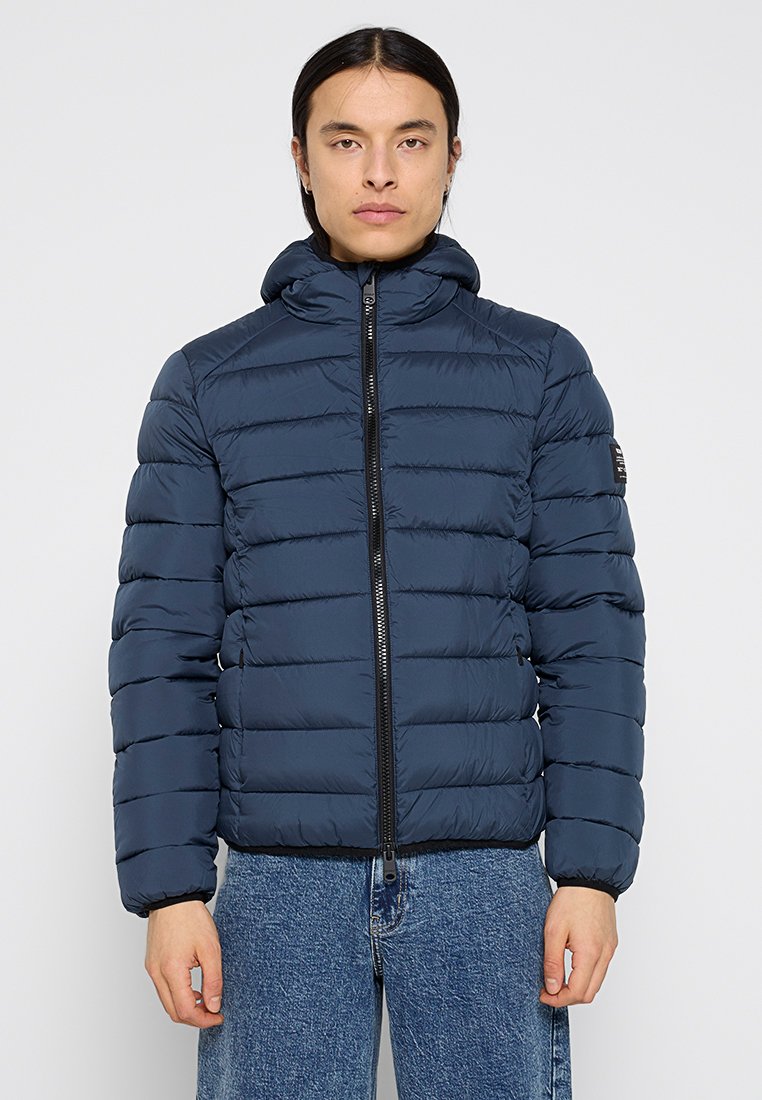 Chaqueta de plumón navy con acolchado horizontal, cremallera frontal y capucha. Tejido texturizado y corte ajustado. Accesorios en color negro.