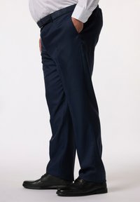Pantalones azul marino hechos de una tela suave, con bolsillos frontales, un diseño de pierna recta y llevados con zapatos negros.