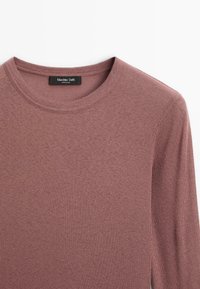 Rippstrick-Langarmshirt in Mauve, mit rundem Ausschnitt und weichem Griff. Etikett trägt die Aufschrift "Massimo Dutti", was auf die Herkunft der Marke hinweist.