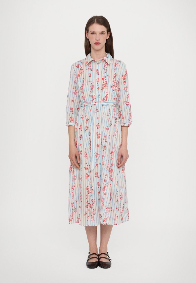 Prugasta srajčna obleka z cvetličnimi vzorci v svetlo modri in rdeči barvi. Dolgi rokavi, pas z obročem in srednja dolžina krila.