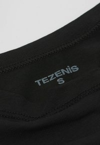 Černý textilní oděv s hladkým povrchem a kulatým výstřihem. Obsahuje viditelnou etiketu s nápisem "TEZENIS" a velikostí "S" v světle modrém textu.