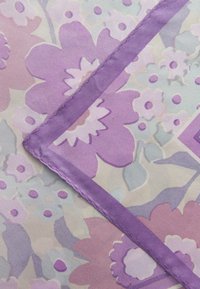 Floral patterned fabric featuring large purple flowers on a pale background, edged with a solid purple trim, smooth texture.