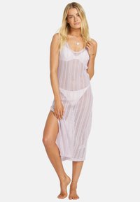 Langer, transparenter, helllila Überwurf aus offenem Strickgewebe mit Rundhalsausschnitt und seitlichem Schlitz, kombiniert mit einem schlichten Bikini darunter.