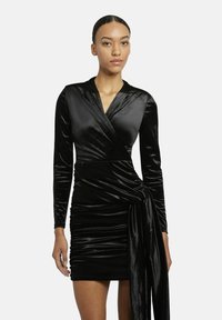 Schwarzes Samt-Wickelkleid mit langen Ärmeln, das mit einem verdrehten Taillendetail und gerafftem Saum versehen ist. Weiche Textur und glatte Oberfläche.