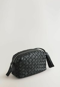 Zwarte leren tas met een geweven textuur, ritssluiting en een kwastaccent aan de zijkant. Compacte, ronde vorm met een gladde afwerking.