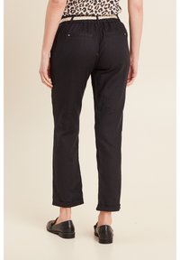 Zwarte lichtgewicht broek met een comfortabele pasvorm, voorzien van een elastische tailleband, opgerolde boorden en twee achterzakken. Eenvoudig ontwerp, geen patronen.