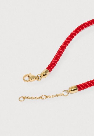 Κόκκινο πλεκτό κορδόνι με μεταλλικά στοιχεία σε χρυσαφί απόχρωση. Διαθέτει κούμπωμα σε σχήμα αστακού και διακοσμητικό αλυσιδάκι στη μία άκρη. Λείο υφή.