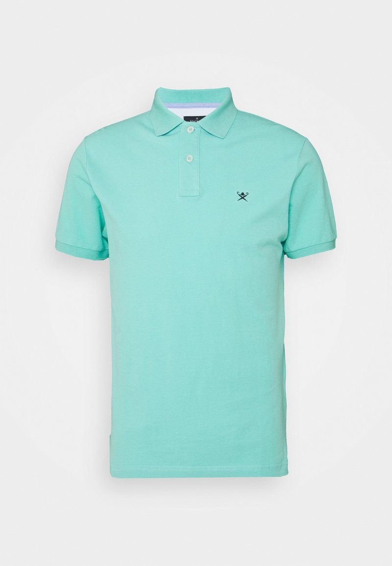 Polo shirt vert clair en coton, avec un col, des manches courtes et un petit logo marine sur la poitrine gauche. Coupe décontractée, texture lisse.
