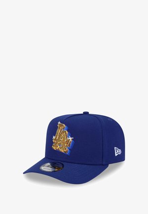 Blue cap with a structured shape, featuring a large embroidered "LA" logo in gold and blue accents. Includes a flat visor and adjustable strap.