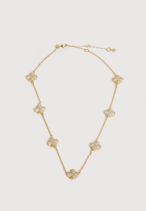 Zlatý retiazkový náhrdelník so siedmimi rovnomerne rozmiestnenými malými príveskami v tvare kvetov, vykladanými trblietavými kryštálmi.