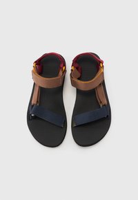Sandalias deportivas negras con correas marrones, burdeos y azul marino, hechas de material texturizado con hebillas ajustables y una plantilla acolchada.