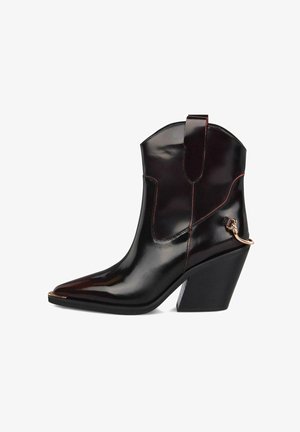 Schwarze Lackleder-Cowboyboots mit einer spitzen Zehe, roten Nähten und einem klobigen Absatz. Mit einem metallischen Akzent am Knöchel.