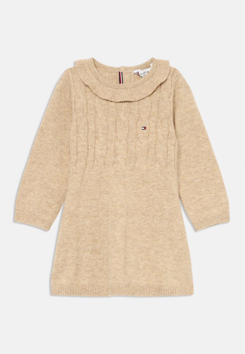 Beige pletené šaty s kabelovým vzorem, žebrovaným límcem a manžetami, dlouhými rukávy a akcentem loga na hrudi. Jemná textura a volný střih.