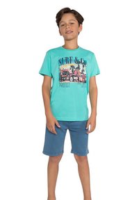 Turquoise T-shirt met korte mouwen en een grafische print van auto's en surfplanken. Gecombineerd met blauwe denim shorts, eenvoudig ontwerp, zachte textuur.