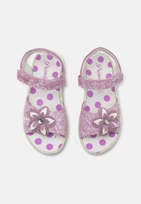 Rosa Sandalen mit floralem Dekor, glänzender Oberfläche, verstellbaren Riemen und einem gepunkteten Sohlenmuster. Mit einem Strass-Akzent.
