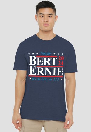 Navyblaue Baumwoll-T-Shirt mit weißem und rotem Text, der "Wählt BERT 2024 ERNIE" mit Sternelementen und Slogan darunter zeigt.