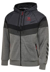 Grå og sort hættetrøje med lynlås, polstret brystsektion, røde detaljer og sidelommer med lynlås. Har chevronmønster på ærmerne.
