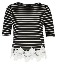 Raitaverinen musta-valkoinen paita, jossa on kolme neljäsosaa hihat ja valkoinen pitsikukka-reunus helman kohdalla. Sileä kangas ja rento istuvuus.