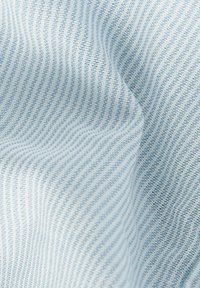 Tessuto blu chiaro caratterizzato da un sottile pattern a strisce testurizzate, che mette in evidenza una superficie liscia e morbida con una caduta ondulata.