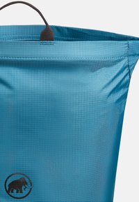 Blå ripstop-förpackning med en strukturerad yta, med ett grått handtag och en svart elefantlogotyp längst ner.