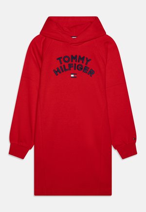 Rode hoodie-jurk gemaakt van zachte stof, met een groot geborduurd "TOMMY HILFIGER" logo in marineblauw. Voorzien van een kangaroo-zak aan de voorkant.
