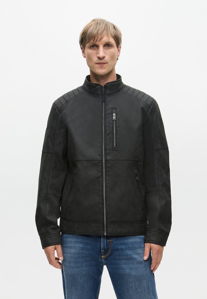 Czarna kurtka z ekoskóry z pikowanymi akcentami na ramionach, z przodu zapinana na zamek, z dwoma kieszeniami bocznymi i kieszenią na piersi. Swobodny krój.