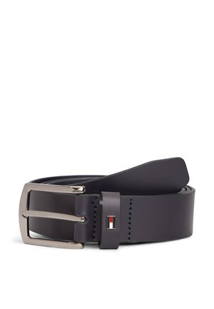 Cinturón de cuero negro con hebilla rectangular plateada y un pequeño logo rectangular rojo, blanco y negro en la presilla del cinturón.