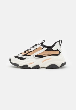 Chunky white, black, and tan sneaker with thick sole and "Steve Madden" logo on side, featuring mesh and leather materials.