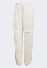 Vita träningsbyxor med elastisk midja, samlade muddar och sidodetaljer; tillverkade av mjukt, lätt tyg.