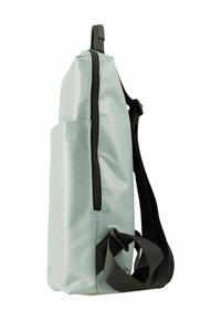 Un sac à dos gris clair au texture synthétique lisse, avec une fermeture éclair noire et des sangles, ainsi qu'une poche latérale pour un rangement supplémentaire.