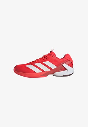 Red athletic shoe made of mesh material with a textured surface, featuring white stripes and a supportive heel clip.