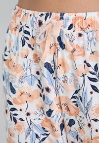 Blumen-Pyjama-Hosen mit einer pastellfarbenen Palette in Pfirsich-, Blau- und Marineblüten, einem elastischen Bund und einem Zugbanddetail.