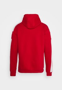 Rode hoodie met een ruime capuchon, witte zijstrepen en geribde manchetten en zoom. Gemaakt van zachte stof met een gladde textuur.